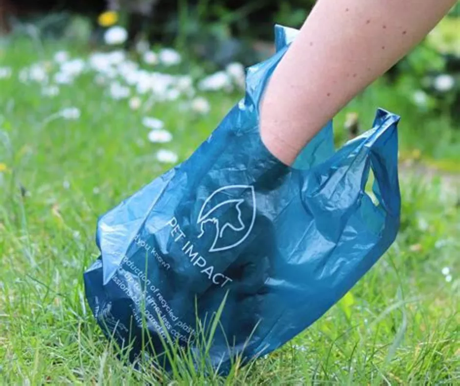A poo bag in use amongst grass