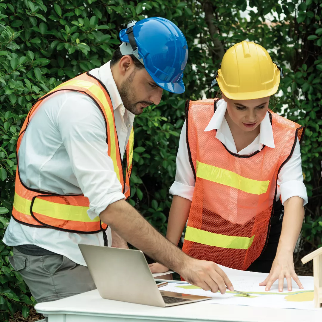 Two people in high vis refer to a construction plan